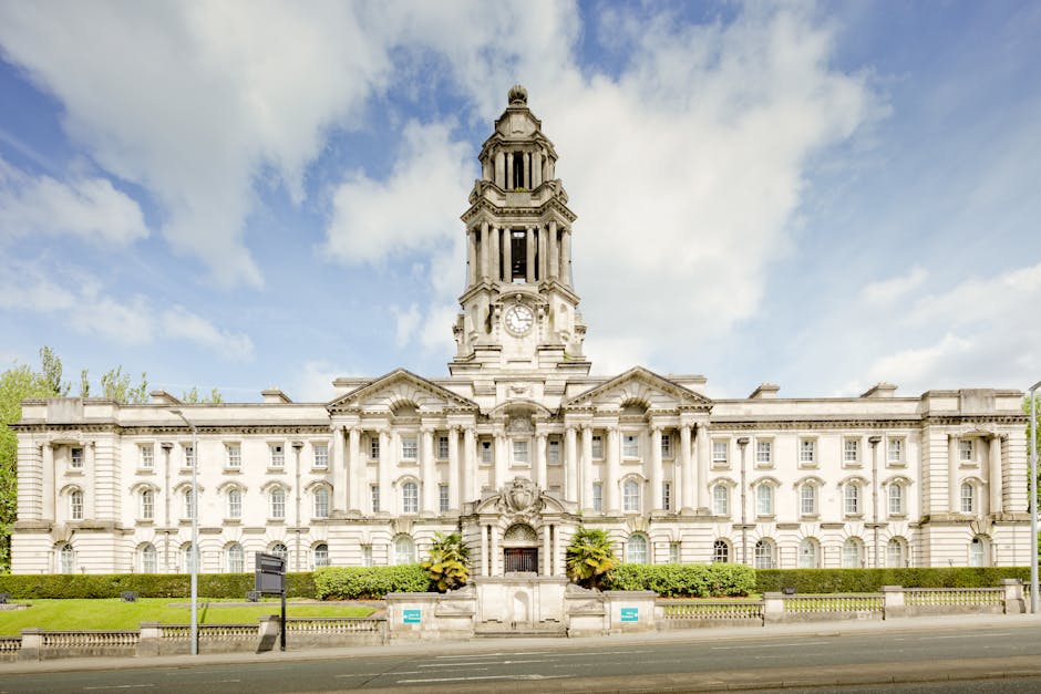 A large historic building with classical architectural features, including a central dome topped with a small spire, two smaller domed towers on either side, and ornate windows along the facade. The s